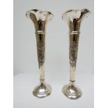 A tall pair of Edwardian silver specimen vases decorated with classical maiden playing a harp,