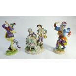 Two Dresden porcelain figurines of court jesters and a pastoral group of shepherd and shepherdess