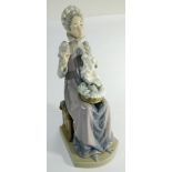 A large Lladro figurine of a seated lady sewing approx 30cms tall