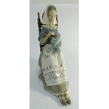 A large Lladro figurine of a seated lady sewing approx 30cms tall.