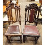 A pair of Victorian carved oak hall or dining chairs with carved lions backs