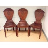 A set of 3 matching Georgian mahogany hall chairs with shield shaped backs with sunburst tops