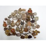 Collection of approx 40+ helmet plates, cap badges and shoulder titles etc,