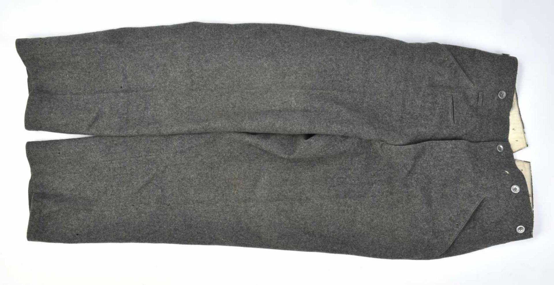 Pantalon gris pierre en drap gris pierre, tous les boutons sont présents. Intérieur en tissu coton