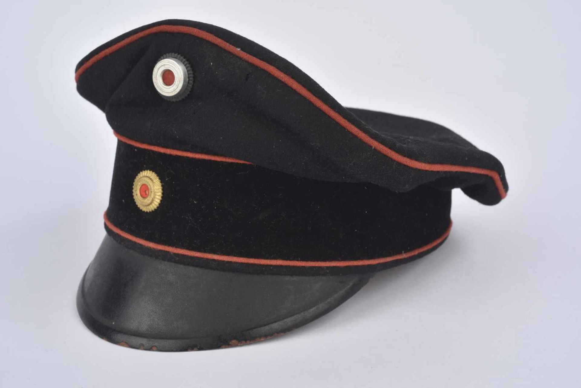 Casquette Schirmmütz bandeau velours noir, drap noir et liseré rouge. Trou de mites. Trous d'