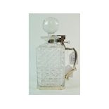 EXTRA LOT: A glass decanter and stopper, with silver plated tantalus style mounts,