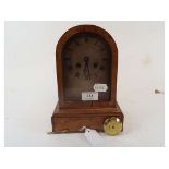 A mantel clock, the silver arched dial w