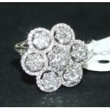 An 18ct gold and seven diamond daisy clu