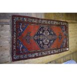 A Persian rug, decorated a medallion on a blue ground,