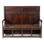 A 17th century oak and elm box settle, with a hinged back section,