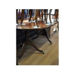 A Regency style inlaid mahogany twin pillar dining table, inset an extra leaf,