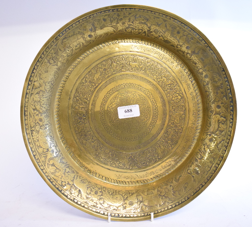 An Eastern brass bowl, with engraved scrolling decoration,
