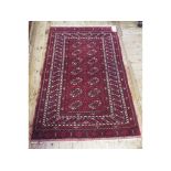 A Bokhara rug, decorated ghul motifs on a red ground,