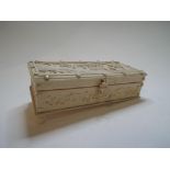 An early 20th century carved ivory box and cover, decorated figures in a landscape,