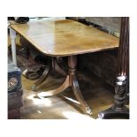 A Regency style inlaid mahogany twin pillar dining table, inset an extra leaf,