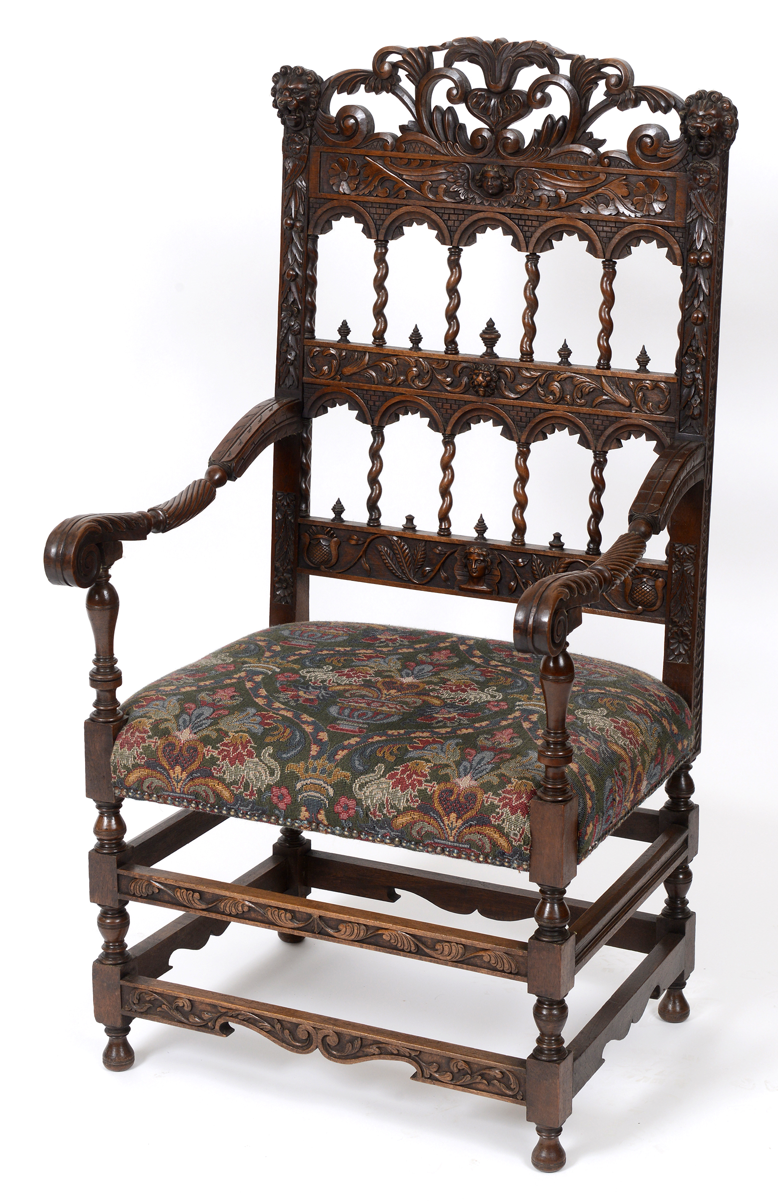 A 17th century style Continental walnut armchair, carved cherub masks, lion masks,