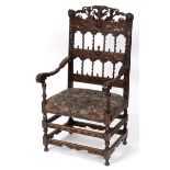 A 17th century style Continental walnut armchair, carved cherub masks, lion masks,