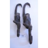 Two graduated carved wood monkey hooks,