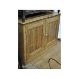 A stripped pine two door cupboard, 109 cm wide,