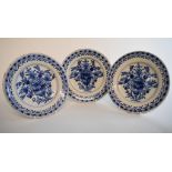 A set of three 19th century Dutch Delft plates, decorated vases of flowers in underglaze blue,