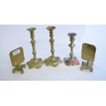 A pair of brass candlesticks, another similar,