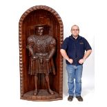 A life size carved oak figure, of Henry VIII, standing in a corner alcove,