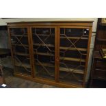 An Edwardian oak bookcase, having three bar glazed doors enclosing adjustable shelves,