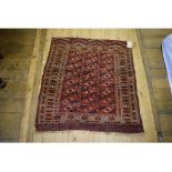 A Turkoman rug, decorated geometric shapes on a red ground, within a multi border,