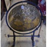An Arts & Crafts brass dinner gong, on a wrought iron frame, 75 cm high,