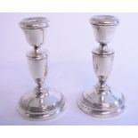 A pair of silver candlesticks, Birmingham 1934, loaded, 14 cm high, a pair of binoculars,