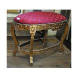 An oval carved giltwood stool, with an upholstered top,