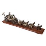 An Indian silver coloured metal carriage, with attendants, pulled by a team of six horses,