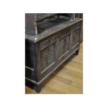 An oak coffer, carved lunettes and flowerheads,