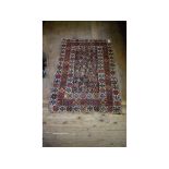 A Persian rug, decorated geometric shapes on an ivory ground, within a multi border,