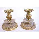 A pair of Eastern squat brass candlesticks