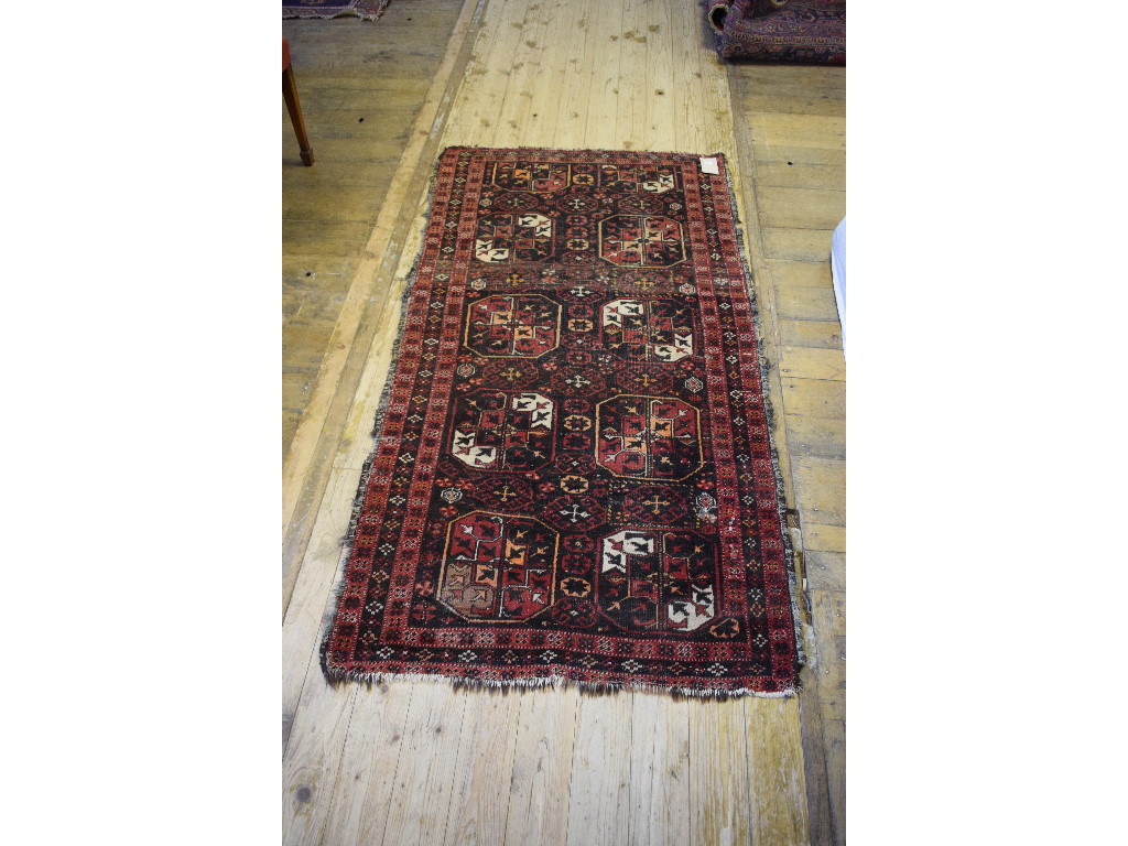 An Afghan rug, decorated motifs on a bla