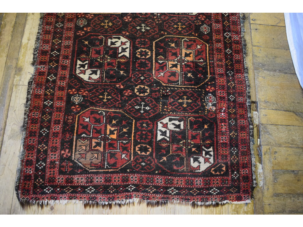 An Afghan rug, decorated motifs on a bla - Image 3 of 4