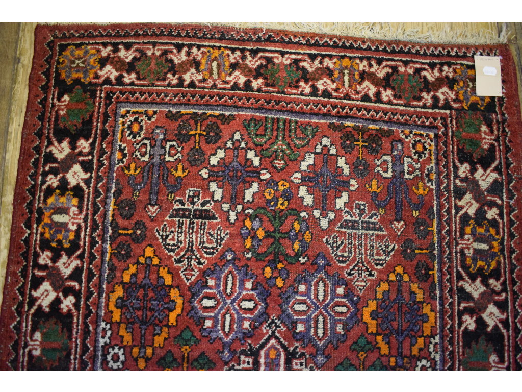 A Persian rug, decorated shapes on a red - Image 4 of 4