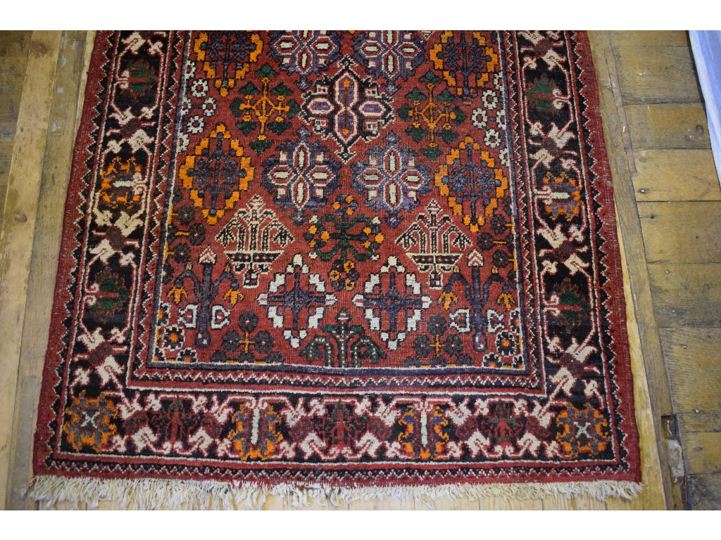 A Persian rug, decorated shapes on a red - Image 3 of 4