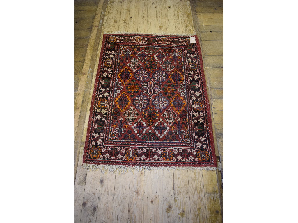 A Persian rug, decorated shapes on a red