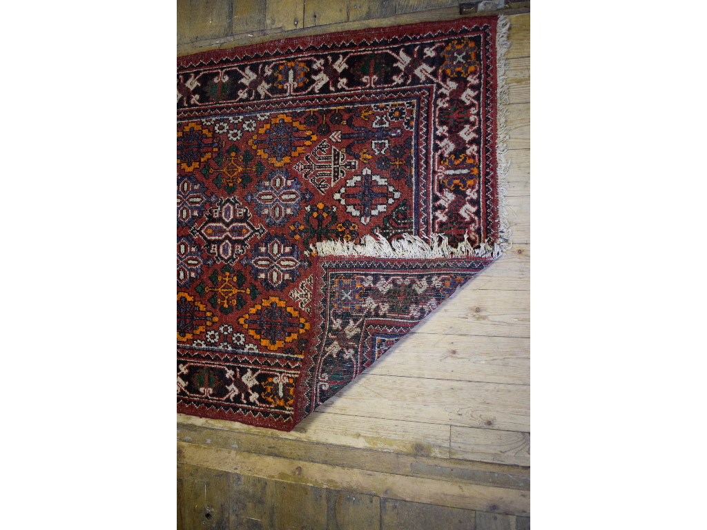 A Persian rug, decorated shapes on a red - Image 2 of 4