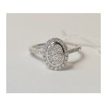 A 9ct white gold and oval diamond cluste