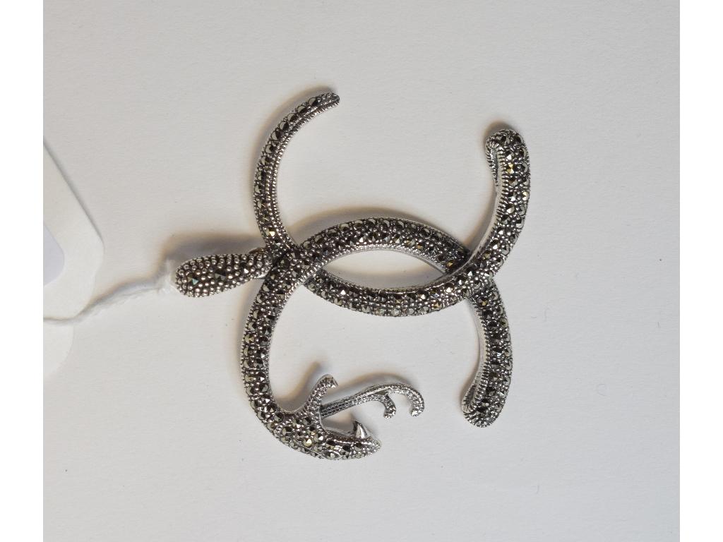 A silver coloured metal snake bangle, se