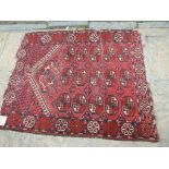 A Turkoman prayer rug, decorated motifs on a red ground, within a multi border,