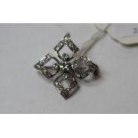 A diamond brooch/pendant, of open quatrefoil form,