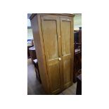 A tall pine two door cupboard,