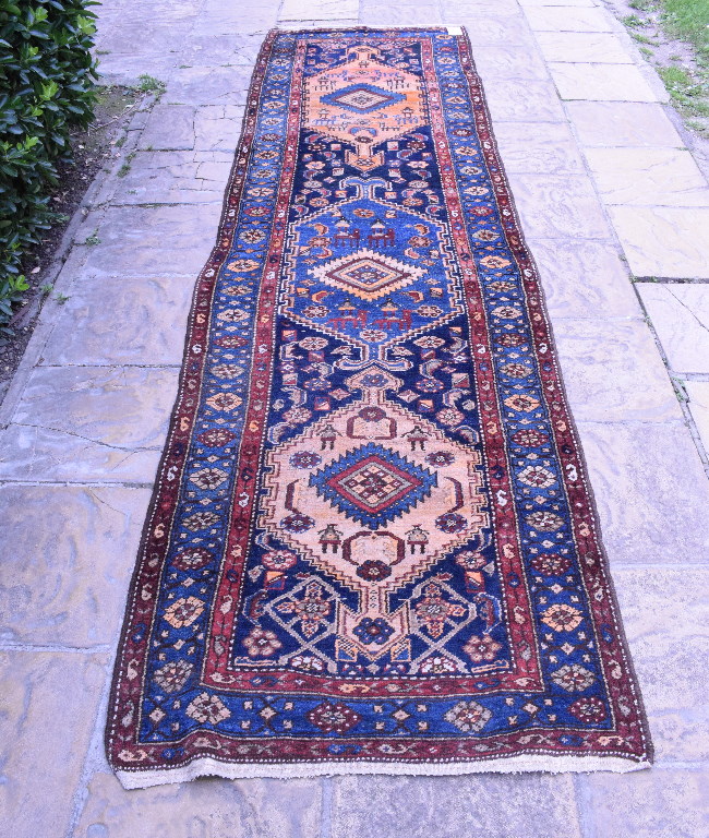 A Persian Nahavand runner, with motifs on a blue ground within a multi border,