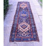A Persian Nahavand runner, with motifs on a blue ground within a multi border,