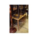 A Danish nest of three teak tables, the largest 57 cm wide, a revolving bookcase, a piano stool,