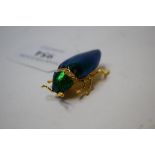A gold plated iridescent brooch,